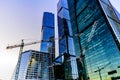 Construction cranes against the background of the international business center `Moscow City` on a winter evening.