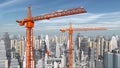 Construction cranes in front of a city landscape