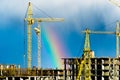 Construction cranes industrial city rain rainbow