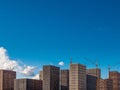 Construction cranes near residential buildings under construction in the city on a sunny day against a blue sky Royalty Free Stock Photo