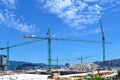 Vigo, Spain, 06/07/2020:Construction cranes on a construction site with buildings behind on a blue sky background with some clouds