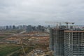 Construction cranes standing near unfinished multi storey buildings