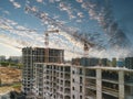 Construction cranes and top of the building with construction workers Royalty Free Stock Photo