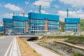 Construction cranes towering above highrise buildings being build in rural setting