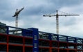 Construction Cranes Works Over Concrete Frame Of New Building