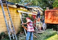 Construction crew dismantles a porch during a roofing job