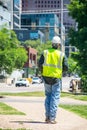 Construction Crew member takes a break and walks down the side walk downtown Royalty Free Stock Photo