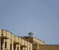 Construction crew working on roof against blue sky Royalty Free Stock Photo