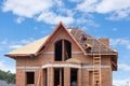 Construction crew working on the roof sheeting of new house made with bricks. Royalty Free Stock Photo