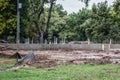 Construction delayed by rain - the foundation of a house poured with plumbing pipes sticking up but very wet soil - Selective