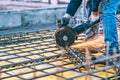 Construction details with worker cutting steel bars and reinforced steel with angle grinder. Filtered image