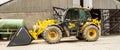 Construction digger loader in farm yard with barn Royalty Free Stock Photo