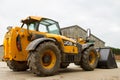 Construction digger loader in farm yard with barn Royalty Free Stock Photo