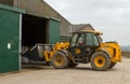 Construction digger loader in farm yard with barn Royalty Free Stock Photo