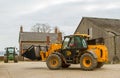 Construction digger loader in farm yard with barn