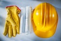 Construction drawings building helmet protective gloves on white