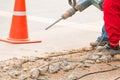 Construction drilling repair worker on road surface with heavy duty machine drill motion Royalty Free Stock Photo