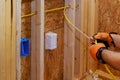 During construction, an electrician connects wires to a socket box Royalty Free Stock Photo