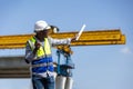 Construction engineer giving instructions at building site with crane, industrial supervisor using walkie talkie directing work at Royalty Free Stock Photo