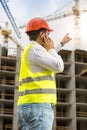 Construction engineer pointing with finger at building under con Royalty Free Stock Photo