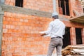 Construction engineer reading plans, working on building construction site. brick walls, infrastructure on construction site Royalty Free Stock Photo
