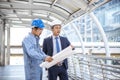 Construction engineer in Safety Suit Trust Team Holding White Yellow Safety hard hat Security Equipment on Construction Site. Royalty Free Stock Photo