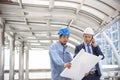 Construction engineer in Safety Suit Trust Team Holding White Yellow Safety hard hat Security Equipment on Construction Site. Royalty Free Stock Photo