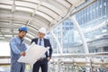 Construction engineer in Safety Suit Trust Team Holding White Yellow Safety hard hat Security Equipment on Construction Site. Royalty Free Stock Photo