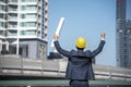 Construction engineer in Safety Suit Trust Team Holding White Yellow Safety hard hat Security Equipment on Construction Site. Royalty Free Stock Photo