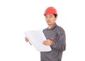 Construction engineer wearing red hard hat standing in front of white background looking at drawings Royalty Free Stock Photo