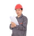 Construction engineer wearing red hard hat standing in front of white background looking at drawings Royalty Free Stock Photo