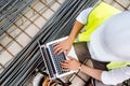 Construction engineer writing report on laptop at construction site