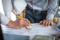 Construction engineering or architect discussing a blueprint and building model while checking information on sketching meeting Royalty Free Stock Photo