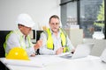 Construction engineers discussing plans with blueprints and digital tablet. Safety, teamwork, planning, and architecture Royalty Free Stock Photo
