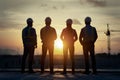 Construction engineers overlooking site silhouette at sunset photo Royalty Free Stock Photo