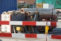 Construction equipment for civil engineering construction site bordered by barrier planks and yellow warning light