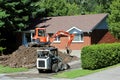 Construction equipment excavating suburban home