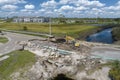 Construction equipment at roadworks site. Reconstruction of damaged road bridge destroyed by river after flood water Royalty Free Stock Photo