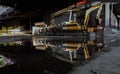 Construction excavator of yellow color and Old waters pumps with reflection on water Royalty Free Stock Photo