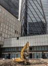 A construction excavator of yellow color is parked in front of the building construction site Royalty Free Stock Photo