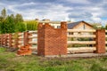 Construction of a fence of bricks and wood