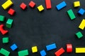 Construction game for kids. Wooden building blocks, toy bricks on black background top view space for text frame Royalty Free Stock Photo