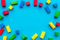 Construction game for kids. Wooden building blocks, toy bricks on blue background top view copy space frame Royalty Free Stock Photo