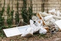 Construction garbage after apartment repair. Pile of construction waste near a white brick wall. Construction debris in white bags Royalty Free Stock Photo