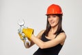 Construction girl in an orange helmet. holding a spanner. Posing while working twisting the imaginable bolt