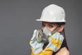 Construction girl in a white hard hat and protective construction mask, for heavy work where you need protection from inhaling