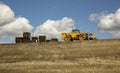 Construction grading equipment and pallets on a steep hill against a blue sky Royalty Free Stock Photo