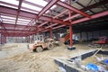 Construction of the hangar. Backhoe working, truck uloading sand