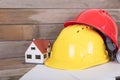 Construction hard hat and drawings and a small house model Royalty Free Stock Photo