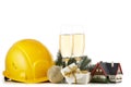 Construction hard hat, fir tree branches, model house, two glasses with champange and Christmas ornament isolated on a white Royalty Free Stock Photo